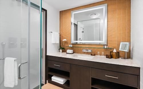 Bathrooms feature large glass enclosed showers, a granite top vanity & L'Occitane Bath Amenities