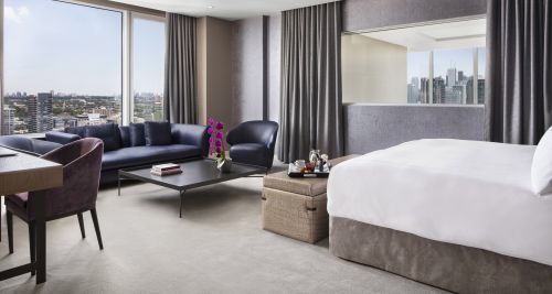 Bedroom with 1 king bed and seating area on the top level of the Penthouse.