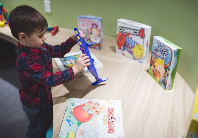 A young boy trying to choose among board games at the Play Centre at 10XTO, where parents can drop off their young ones for up to 3 hours.