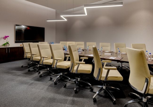 The Champion's Boardroom has a built-in table with 16 armchairs and elegant bright lighting for corporate presentations and meetings.