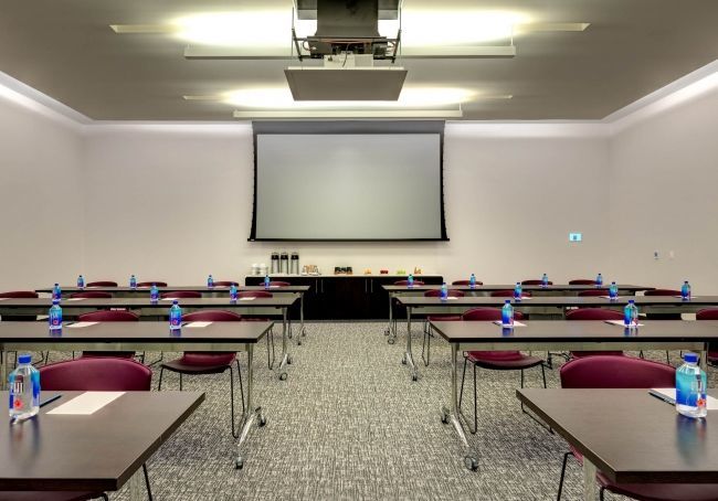 A classroom-style set-up with a drop-down screen for corporate events.